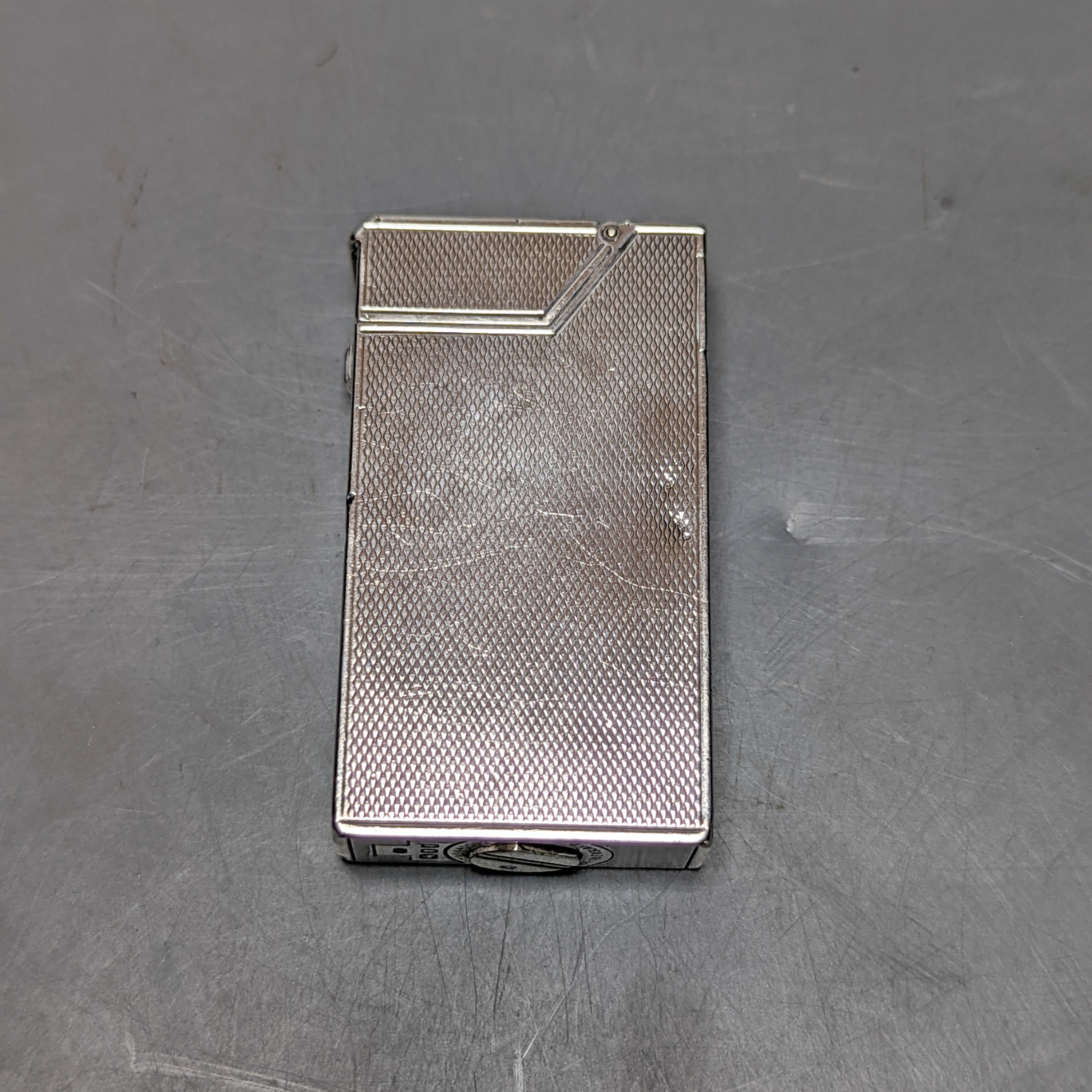 A George VI engine turned silver mounted Dunhill lighter, London, 1945, 57mm.